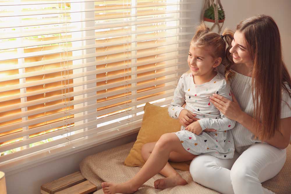 Woman and child near window blinds